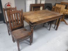 A contemporary hardwood dining table and three chairs