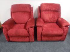 A pair of red electric reclining armchairs