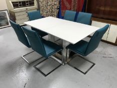 A contemporary white high gloss dining table on metal base,