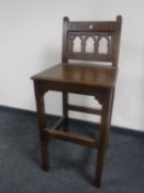 A carved oak Gothic style high chair