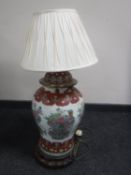 A Chinese floral pottery table lamp with shade on wooden base