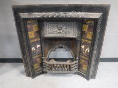 A Victorian cast iron fire with tiled panels