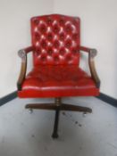 A red buttoned leather Chesterfield style swivel chair