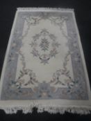 A fringed floral Chinese embossed rug on cream ground