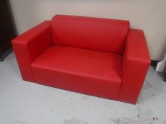 A vinyl two seater settee with scatter cushions