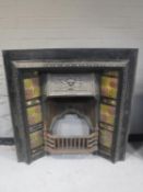 A Victorian cast iron fire with tiled panels