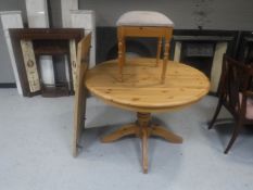 A circular pine extending table with leaf and a pine dressing table stool