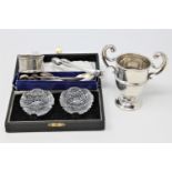 A miniature silver trophy, silver sugar tongs and other flatware,