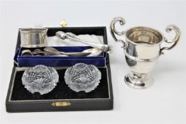 A miniature silver trophy, silver sugar tongs and other flatware,