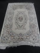 A fringed floral Chinese embossed rug on cream ground