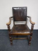 An Edwardian oak armchair in buttonned leather