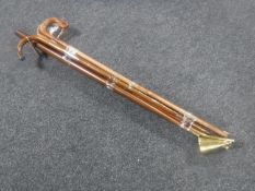 A bundle of 20th century walking sticks and a brass headed candle snuffer