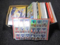 A box containing a quantity of football sticker albums, Match Attax trading card annuals,