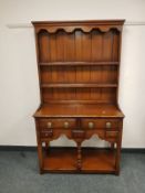 A reproduction yew wood dresser of neat proportions,