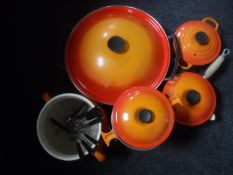 Five pieces of Le Cruset ware - wok with lid, fondue dish on stand,