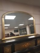 An arched Victorian style gilt overmantel mirror,