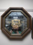 An octagonal framed mirror bearing Morris Minor advertisement