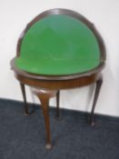 A mahogany D-shaped turnover top games table