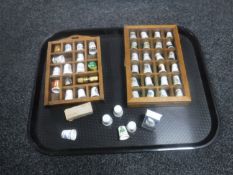A tray of two thimble cases and a collection of thimbles