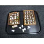 A tray of two thimble cases and a collection of thimbles