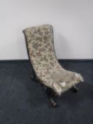 A Victorian ebonised nursing chair in floral fabric