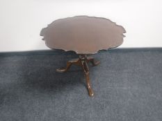 A walnut pie crust edge tilt top coffee table