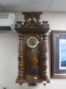An antique mahogany cased Vienna wall clock with pendulum and key