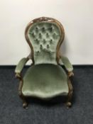 A Victorian armchair in green button dralon
