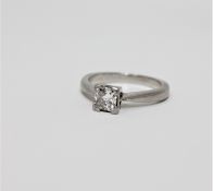 A platinum diamond solitaire ring, the princess-cut stone weighing an estimated 0.