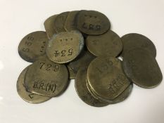 Nineteen vintage brass railway pay check tokens.