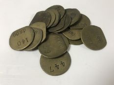 Nineteen vintage brass railway pay check tokens.