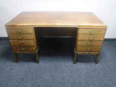 A mid 20th century walnut twin pedestal writing desk