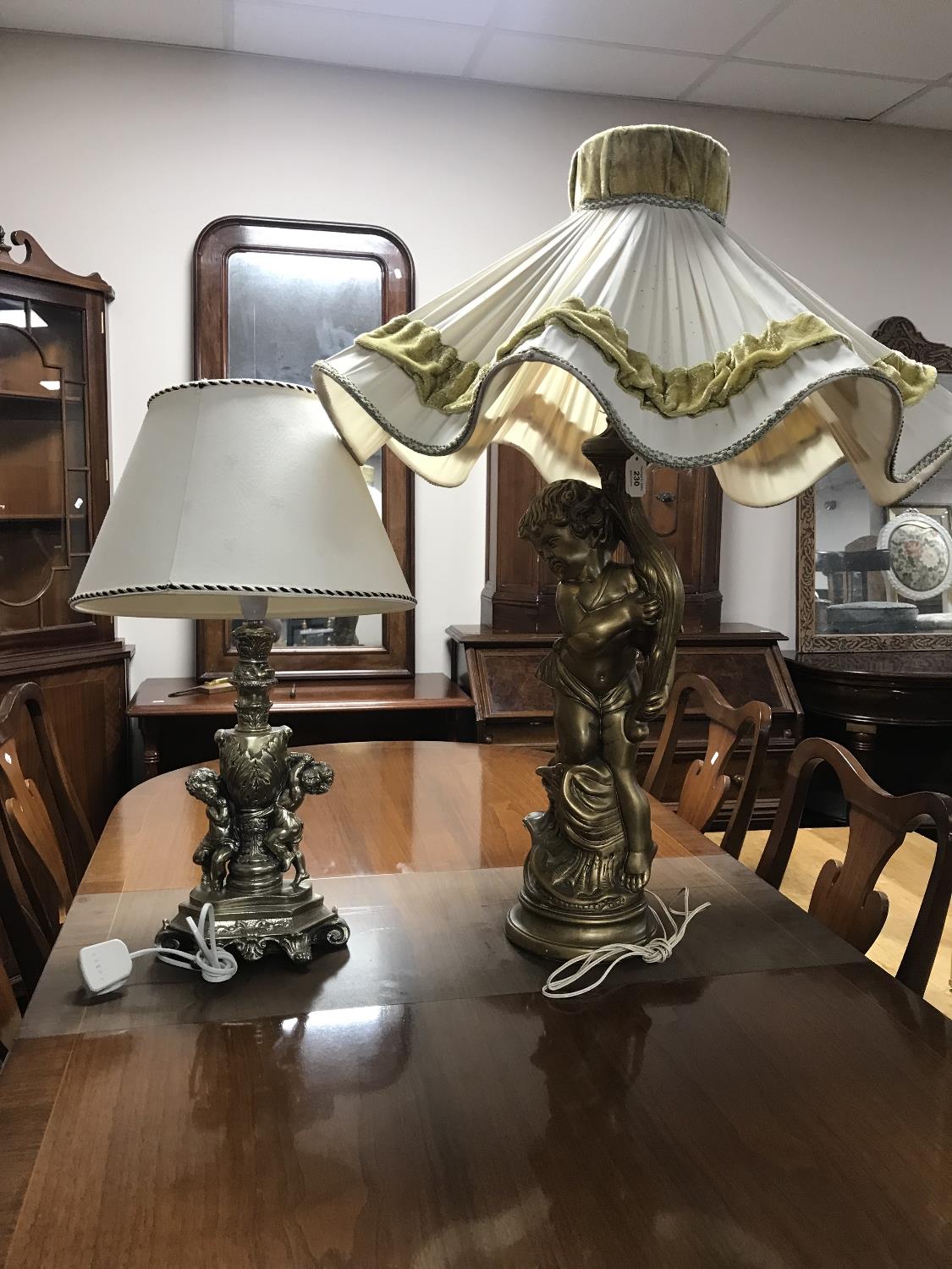 A figural chalk table lamp of a cherub plus another similar with shade