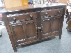 An Ercol stained elm double door sideboard fitted two drawers