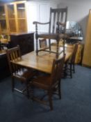 An early 20th century oak pull out dining table on barley twist legs together with a set of five