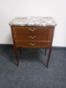 An inlaid mahogany three drawer bedside chest with brass mounts,