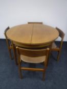 A circular 1970's teak extending dining table and four chairs