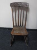 An Edwardian carved oak rocking chair