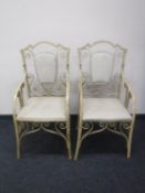 A pair of wrought iron shield back garden armchairs