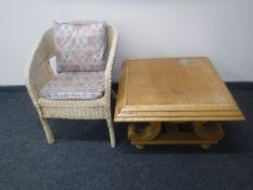 A square oak coffee table together with a wicker basket chair