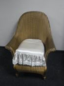 A mid 20th century gold Lloyd Loom armchair