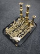 A tray of antique brass trivet, candlesticks,