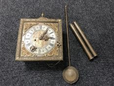 A brass wall clock with weights and pendulum