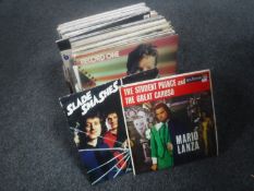 A box of LP records including Now compilations, Kiss,