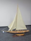 A large wooden model of a yacht on stand