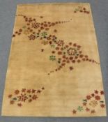 A hand-knotted rug of floral design on gold ground,