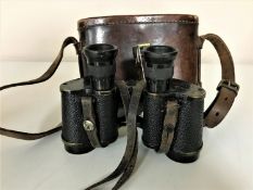 A set of WWI era brass and leather binoculars in leather case bearing the name J Pollard,