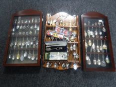 Two display cabinets and a rack containing a large quantity of commemorative spoons