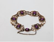 An Edwardian gilt metal bracelet set with purple stones