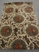 A hand-knotted rug of floral design on brown ground,